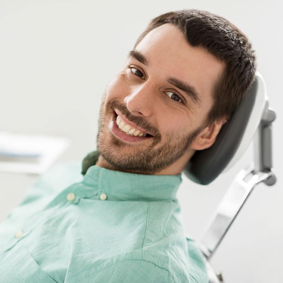 handsome young man relaxing in a dental chair for a cleaning exam