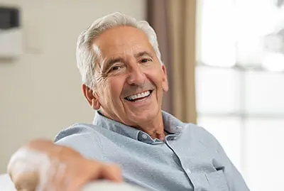Mature gentleman relaxes on his couch while smiling ear to ear