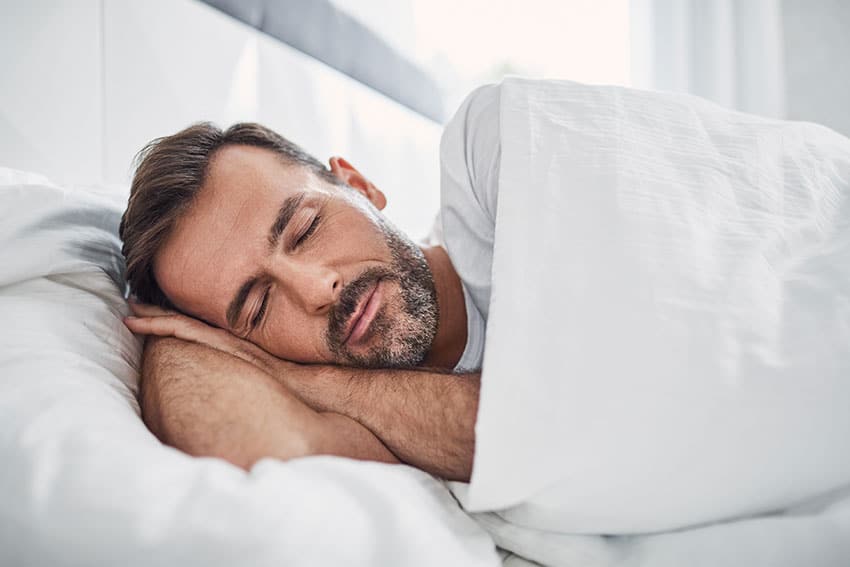 middle aged man sleeping peacefully in bed