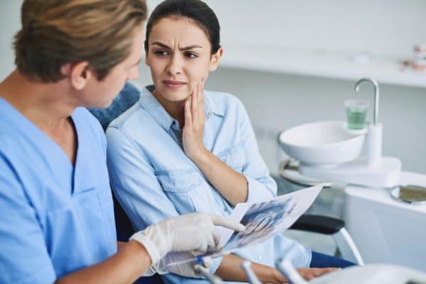 woman discussing her TMJ/TMD pain with her dentist 