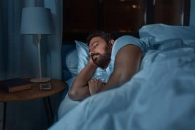 adult man sleeping peacefully in bed